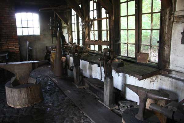 interior of a smithy with anvils and work bench