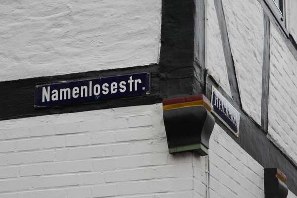 Street sign of Namenlose Straße (Nameless Street) in Glückstadt on a house on the corner to Reichenstraße.