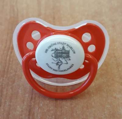 Photo of a red and white pacifier with the inscription "The green city of Marlow. City of the bird park."