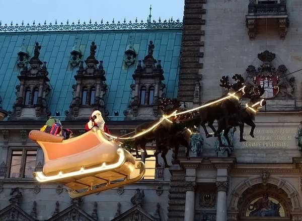 Santa Claus flies above Hamburg’s city hall Christmas market in his sleigh